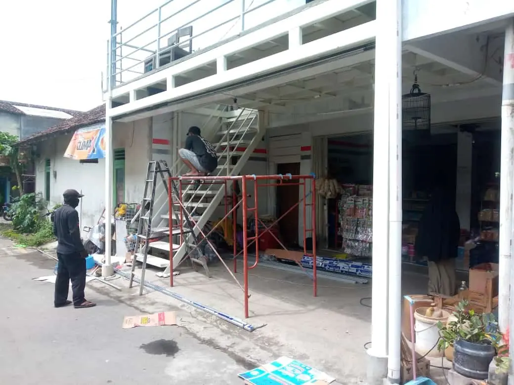 Tangga besi dan struktur mezanin di dalam sebuah ruang usaha
